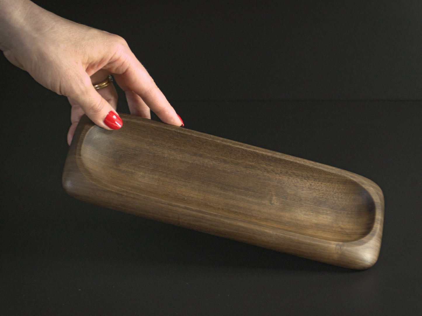 A hand holding wooden nibble board