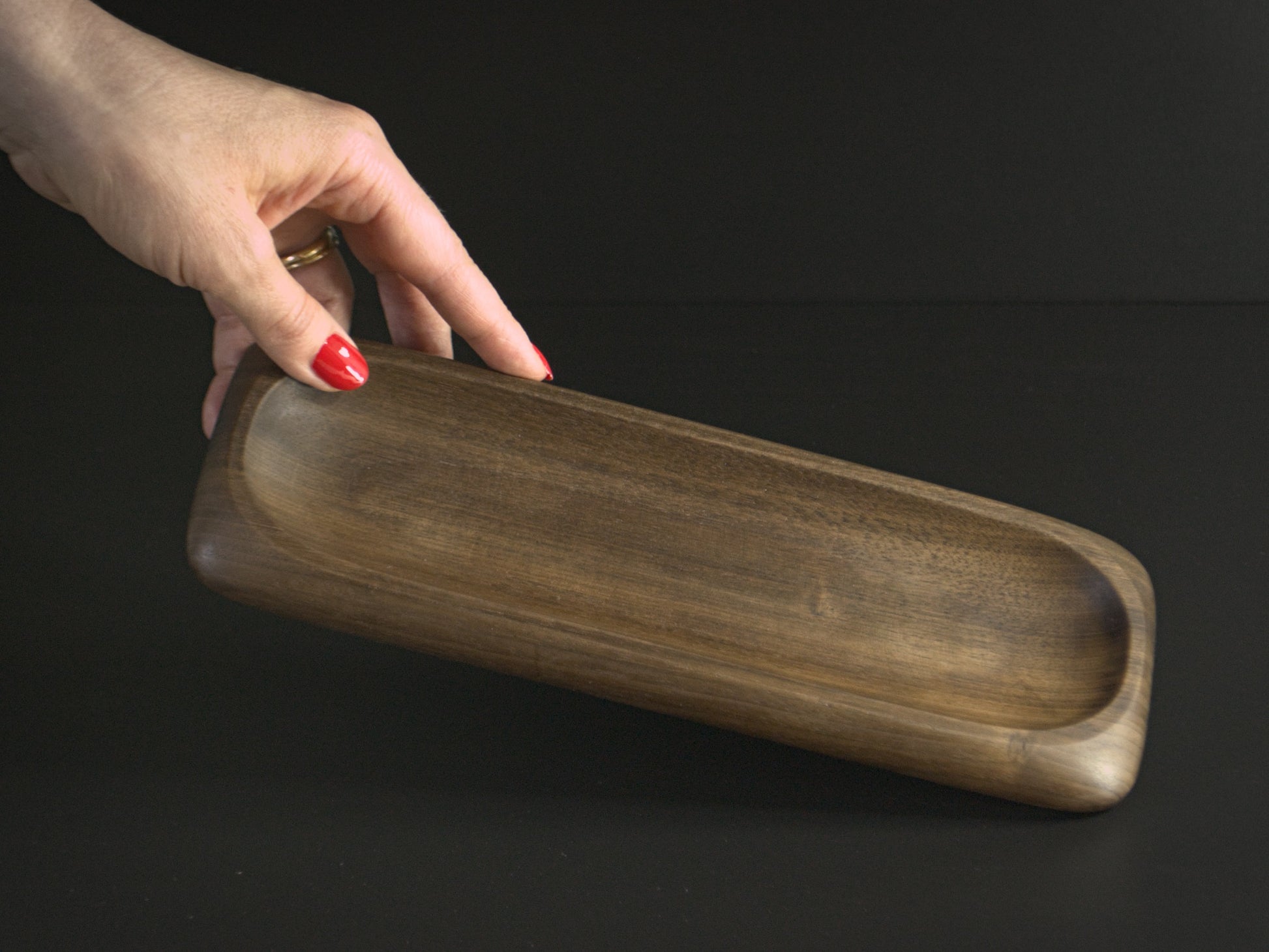 A hand holding wooden nibble board