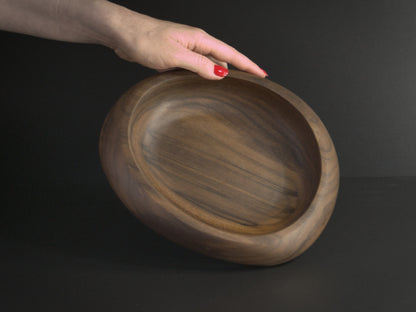 Circular wooden bowl and hand for scale